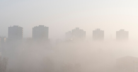 Fog in the city. High buildings in a fog. Skyline. Architecture of town in the morning. Banner and panoramic.