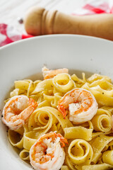 delicious shrimp fettuccine alfredo pasta on a white rustic background
