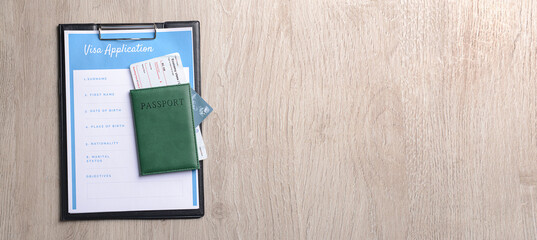 Visa application form and passport on wooden background with space for text. Concept of immigration