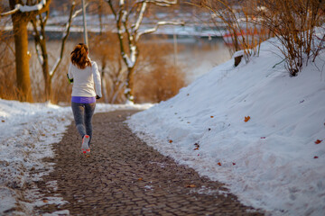 Full length portrait of active woman in white jacket running