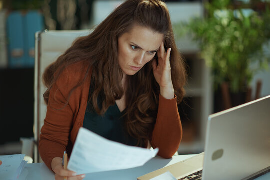 sad business owner woman in green office working with documents