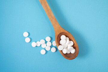 White Vitamin Tablets in Elegant Spoon on Blue Background — Pharmaceutical Concept with Copy Space