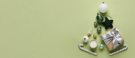 Obraz premium Christmas tree made of decorations, gift and candle on green background with space for text
