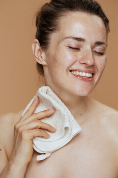 smiling woman with towel washing face