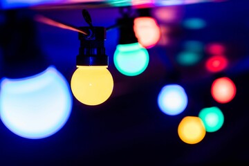Selective focus shot of colorful string lights creating a festive atmosphere on dark blue background