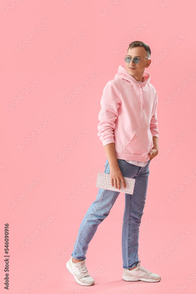 Sticker Young man with computer keyboard on pink background