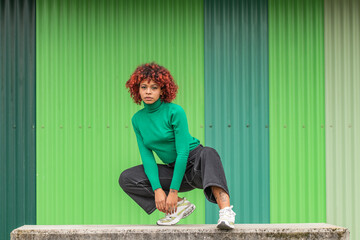 young woman in the street dancing outdoors on green background