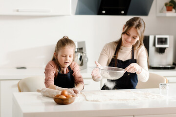 Mom teaches her little daughter 10 years old how to bake cookies. Cooking Homemade Cookies. High quality photo