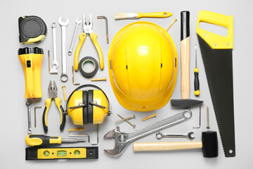 Hearing protectors with builder's tools on light background