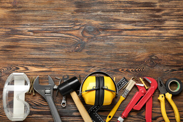 Hearing protectors with builder's tools on dark wooden background