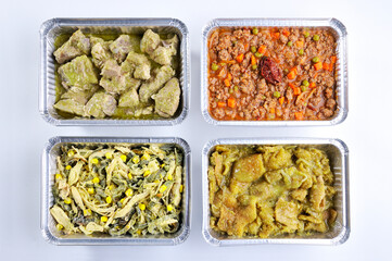 Four aluminum containers with take-away meals