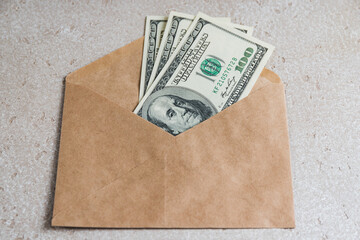 Three hundred cash dollars in a craft envelope on a table. The concept of cash savings.