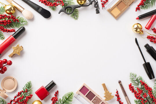 Top view photo of golden baubles cosmetics lip gloss nail polish mascara eyeshadow palettes brushes eyelash curler fir branches mistletoe on isolated white background with empty space in the middle