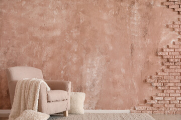 Obraz na płótnie Canvas Stylish armchair with soft plaid near color wall