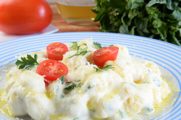 delicious gnocchi pasta in white sauce with parmesan cheese, tomato, basil, herbs, healthy food from Italian and French cuisine