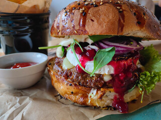 Tasty hamburger with grilled beef, camembert cheese, red onion and cranberry sauce