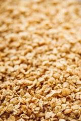 fresh raw buckwheat flakes on a black wooden background