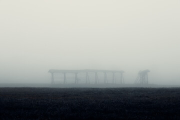 Fog and mist, create mysterious feel over fields in cold autumn morning.
