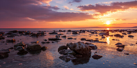 Fototapeta na wymiar Sunning long exposure sunset over the sea with a rocky beach.