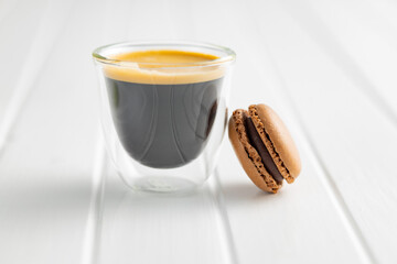 Sweet macaron dessert and coffee cup. Colorful macarons on white table.