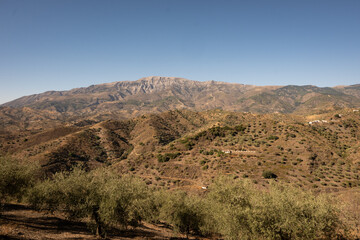 A view of spanish mountains taken from the hill above Arenas in Malaga, Andalusia. These rocky looking mountains are scattered with holiday homes and farms for crops like figs and olives