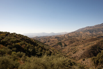 A view of spanish mountains taken from the hill above Arenas in Malaga, Andalusia. These rocky looking mountains are scattered with holiday homes and farms for crops like figs and olives
