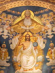 ZURICH, SWITZERLAND - JULY 1, 2022: The fresco of Holy Trinity among the saints in main apse of church St. Anton by Fritz Kunz (1921).