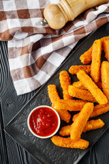 crispy fresh chicken strips on a black rustic wooden background