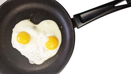 heart-shaped scrambled eggs in a frying pan