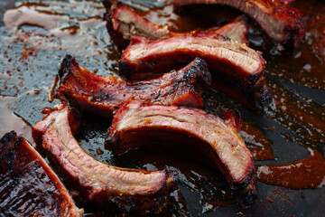 Barbecue pork spare loin ribs St Louis cut with hot honey chili sauce served as close-up on a rustic black board