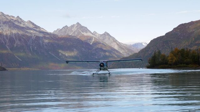 float plane lands on water in alaska in mountain range area near by homer cool avaition plane for travel etc