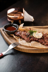 Sliced meat on a wooden board with sauces side view