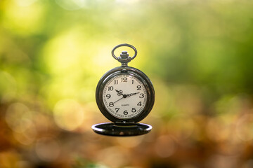 zegarek z białym cyferblatem na jasnym rozmytym tle jako upływ czasu lub Nowy Rok