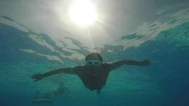 Aquapark. Tourist vacationer male dives underwater in the pool of water amusement park 