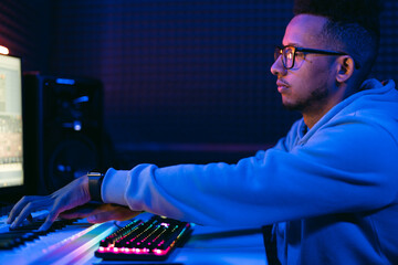 Producer, audio engineer uses a control panel and screen to record a track of a new album in a...