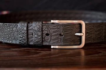 Foto op Plexiglas Leather trouser belt in the background . Men's  fashion accessories closet. Genuine leather, handmade belt  © Iryna