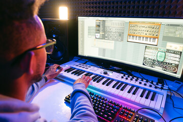 Producer, audio engineer uses a control panel and screen to record a track of a new album in a...