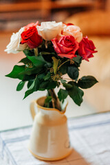 Bouquet of red and white roses in a vase on the table