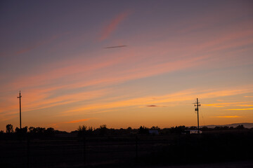 Pretty sunset of farm with power lines 