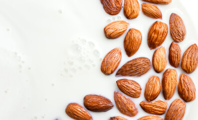 Almond kernels in milk bath closeup. Natural background for healthy food or skin care cosmetics. Selective focus, place for text