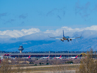 plane landing on the runway of Madrid airport, in front of the terminal 4 tower.