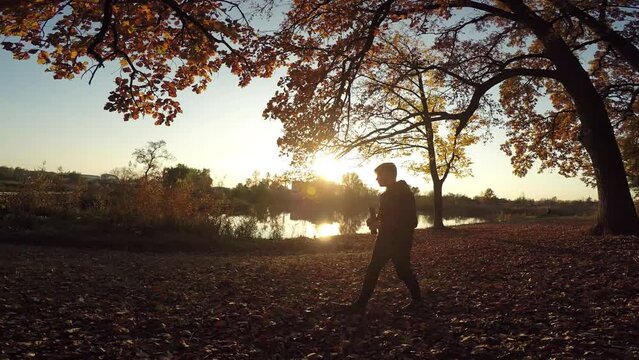 Caucasian boy guy teenager photographer walking in the autumn park