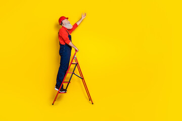 Full size profile side photo of senior workman use tool stepladder change lamp bulb isolated on bright color background © deagreez