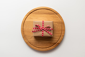 Gift box on wood cutting board. Idea gift