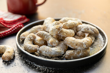 Vanilla crescent cookies on a plate with space for text