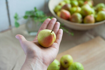 Delicious organic pear fruit on the chef's hand. Natural wooden background.