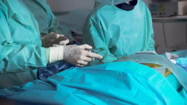 Neurosurgical operation. The surgeon holds in his hands a medical instrument for spine surgery. Close-up.