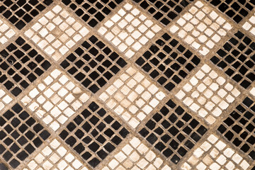 A black and white checker board pattern made with mosaic pieces of stone.