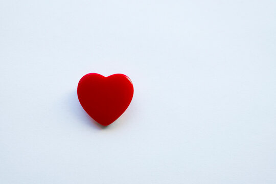 A shiny red heart isolated on a plain background.