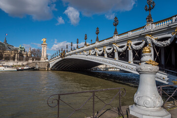 The Pont Alexandre III in Paris France as seen from the banks of the Seine River.